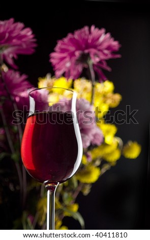 red wine and flowers on a black background
