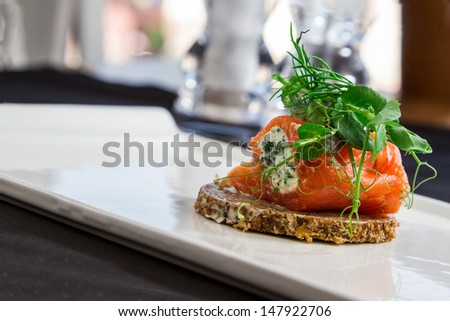 Smoked salmon and cream cheese arranged on white plate