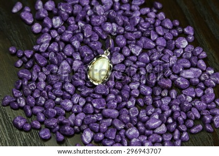 Nacre earring on purple pebbles - Jewelry on colorful pebbles studio series #3.