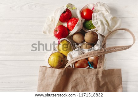 zero waste food shopping. eco natural bags with fruits and vegetables in tote, eco friendly, flat lay. sustainable lifestyle concept. plastic free items. reuse, reduce, recycle, refuse.