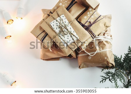A pile of gift boxes in craft eco paper, handmade presents on white background. Greeting card concept