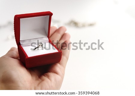 luxury ring with diamond in stylish red box in hand on white background, present and love concept, valentine\'s day proposal