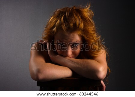Portrait of beautiful red-haired woman on a dark background