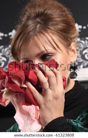 Young woman in the bliss breathe fragrance of rose petals