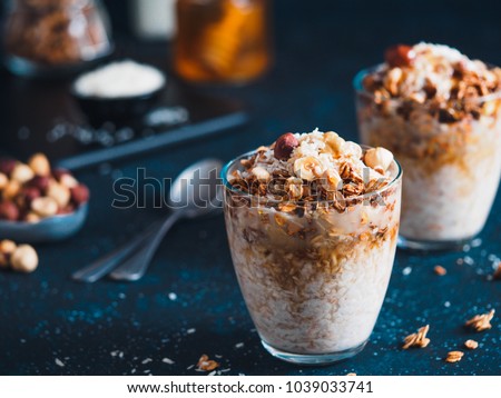 Gingerbread coconut overnight oatmeal served with granola,pecan,honey.Recipe and idea healthy vegan breakfast - plant-based milk overnight oats with chia and gingerbread spices cinnamon, nutmeg,ginger