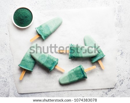 Superfood spirulina popsicles. Ideas and recipes for healthy breakfast, summer vegetarian snack or vegan dessert. Popsicle with spirulina powder and coconut milk. Top view. Copy space for text