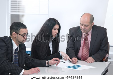 Group of business people formed of two men and a woman working together in the office