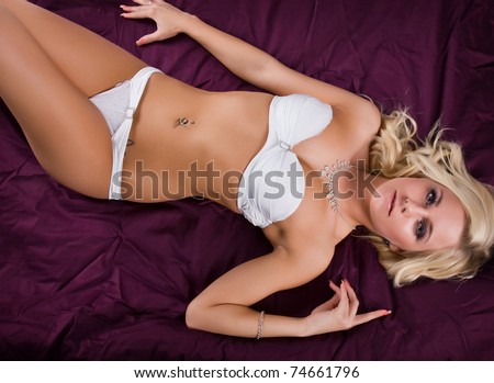 beautiful young woman in white lingerie lying on bed