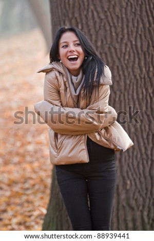 beautiful young woman laughing in autumn park