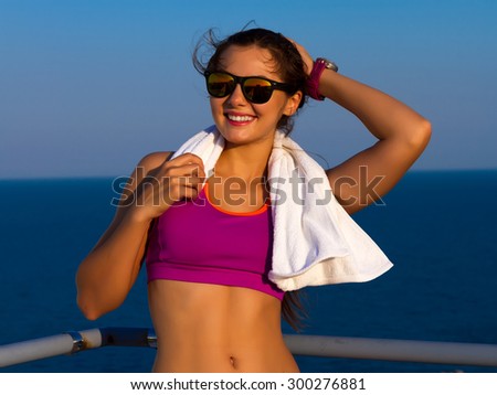 Beautiful young sport woman with towel. cheerful confident young woman with towel after gym portrait.beautiful fit woman with a towel.Portrait of fit tanned caucasian woman holding towel around neck