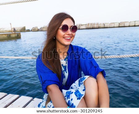 Summer close up fashion portrait of young teenage hipster girl,positive surprised emotions,smile,on the amazing city sea view terrace.Odessa.Travel tourism and people concept. in marina in port