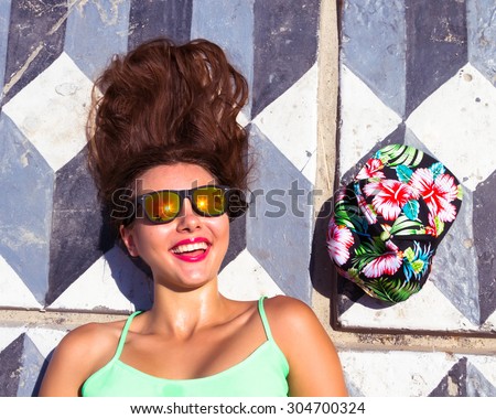 Summer fashion close up Young  tanned hipster girl going crazy, have positive surprised emotions, screaming and laughing, bright summer outfit. Top view,urban style.