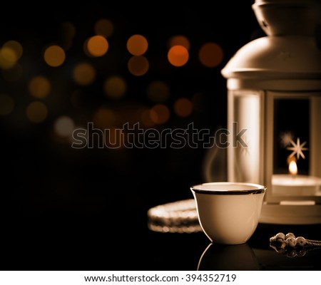 Close up on an Arabian coffee with Lantern and rosary.\
Ramadan mood at night with light decoration in the background.
