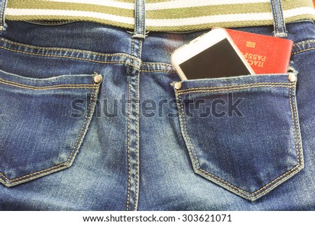 Passort and mobile phone in the pocket of blue jeans, a man goes on a big journey