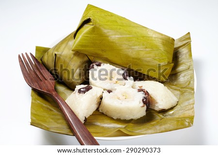 Traditional Thai dessert, Glutinous rice streamed with banana wrap banana leaf. (Khao Tom Mat) isolated on white background