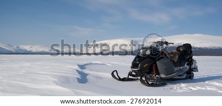 A snowmobile with mountains on the background