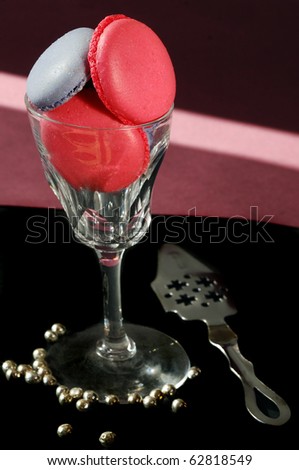 violet and rose colored macaroons with silver balls in an antique glass