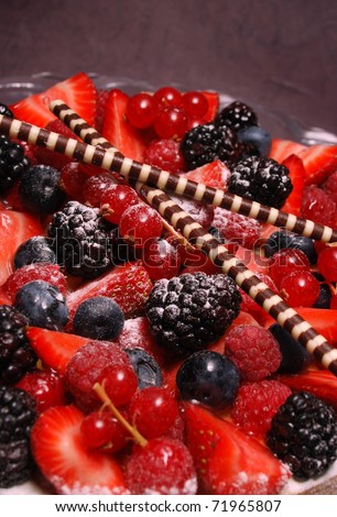 A french summer fruits tart close up cake with a violet background