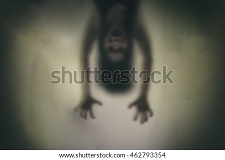 Devil woman hanging upside down, pretending to haunt. Concept blur With noise and dirt