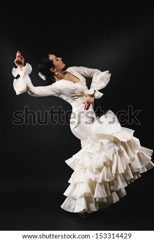 Young woman performing salsa dance with passion on black background