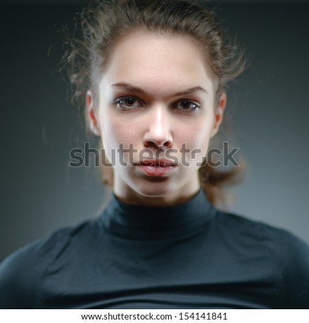 Portrait of a normal girl looking camera. / Beautiful woman portrait over grey background. Shallow depth-of-field.