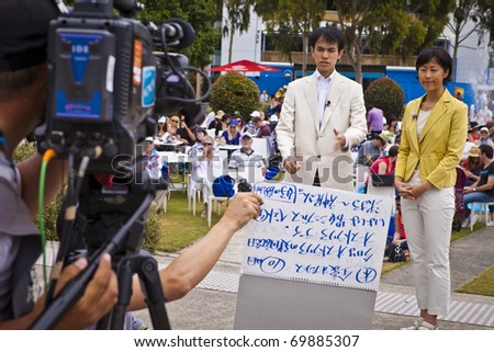 MELBOURNE, AUSTRALIA - JANUARY 26: Asian news crew filming next to Rod Laver Arena which holds the center court at the Australian Open, January 26, 2011 in Melbourne, Australia