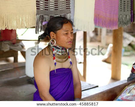 KAREN VILLAGE, THAILAND -  AUG 21:Traditionally dressed Long Ear woman from the Padaung-Karen long-necked tribe sells goods on August 21, 2007 in Karen Village, Thailand