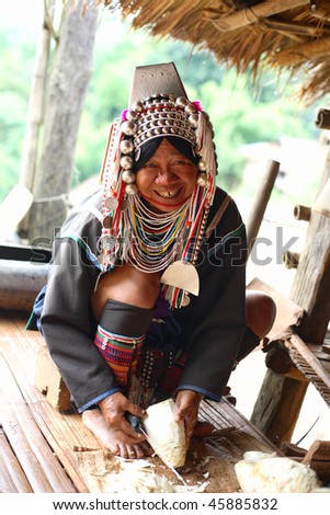 AKHA HILL TRIBE VILLAGE, THAILAND - AUG 24: Traditionally dressed Akha hill tribe woman carries out daily routine on August 24, 2007 in Akha hill tribe village, Thailand.