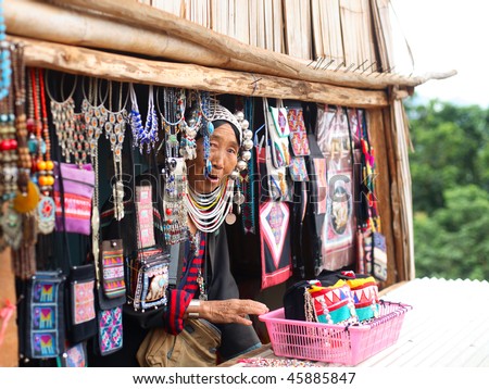 AKHA HILL TRIBE VILLAGE, THAILAND - AUG 24: Traditionally dressed Akha hill tribe woman sells goods at the local market on August 24, 2007 in Akha hill tribe village, Thailand.
