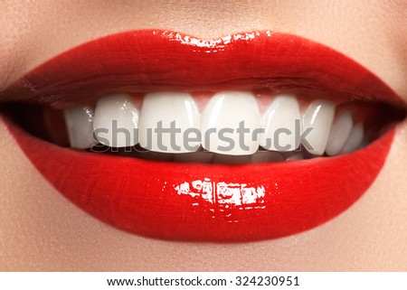 Close up  beauty portrait view of a young woman natural smile with red lips. Classic beauty detail. Red lipstick and white teeth. Closeup of woman smiling with prefect white teeth.