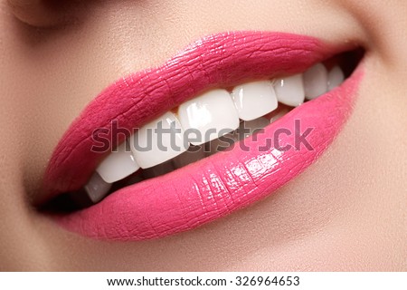 Macro happy woman\'s smile with healthy white teeth, bright pink .lips make-up. Stomatology and beauty care. Woman smiling with great teeth. Cheerful female smile with fresh clear skin