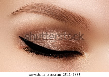 Cosmetics & make-up. Beautiful female eye with sexy black liner makeup. Fashion big arrow shape on woman\'s eyelid. Chic evening make-up