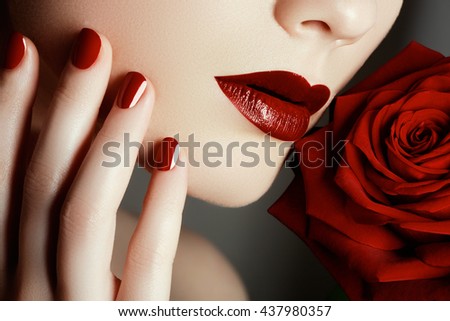 Beauty fashion model woman face. Portrait with red rose flower. Red Lips and nails. Beautiful woman with luxury makeup and manicure