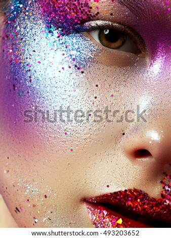 Beauty, cosmetics and makeup. Magic eyes look with bright creative make-up. Macro shot of beautiful woman\'s face with perfect art make up with glitter