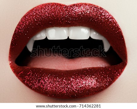 Open mouth of mosnter with fangs. Sexy Woman lips with bloody lipstick. Fashion Glamour Halloween art design. Vampire teeth
