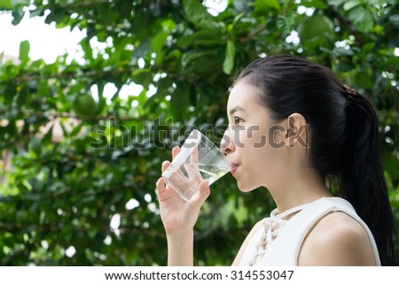 Close-up of pretty girl drinking water from glass