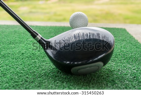 Close-up of a golf ball and a golf wood on a driving range