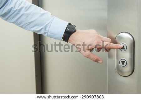 Person pushing up arrow elevator button.