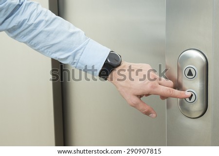Person pushing down arrow elevator button.