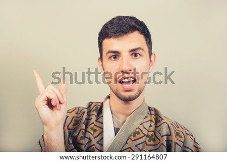 man wearing kimono showing finger above on empty copy space and said - I have an idea