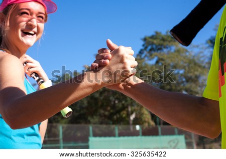 Tennis opponents shaking hands before match on a sunny day
