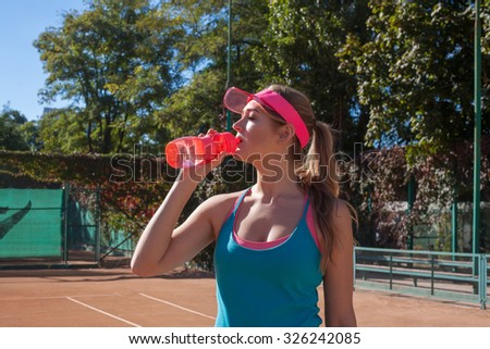 Female tennis player drinking a water