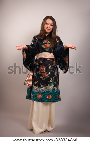 young woman in kimono standing holding her hand showing something on the open palm
