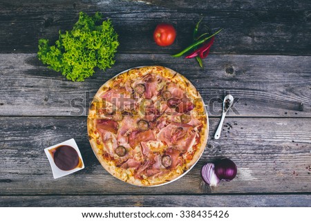 Top view of pizza with meat and rustic decor
