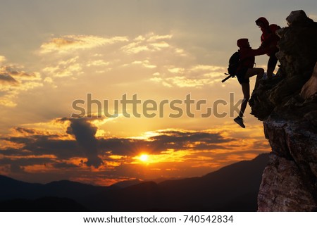 Teamwork hiking help each other trust assistance at mountains and beautiful sunrise,teamwork and hiking concept.