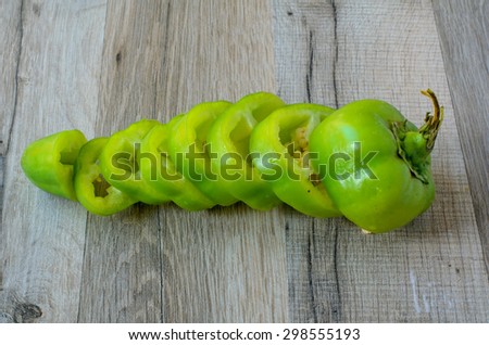 Green pepper cut into slices on grey wooden background