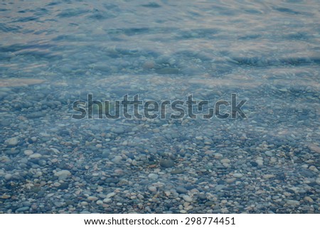 Sea texture of transparent water and pebbles