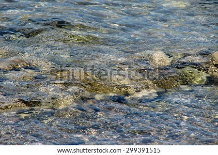 Sea texture of transparent water and pebbles