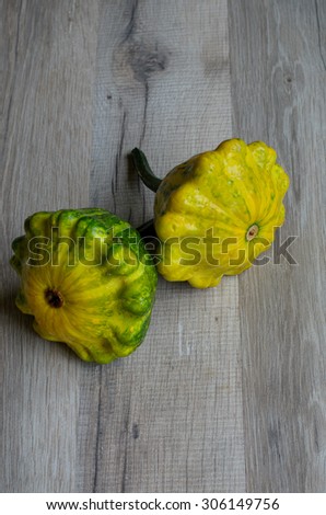 Two green patty pan squashes on wooden background