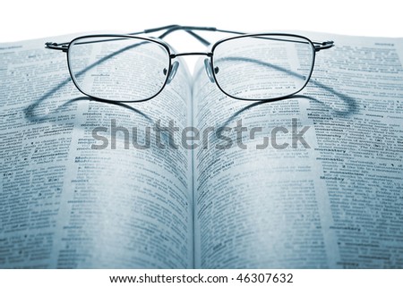 Glasses on the book on the white background